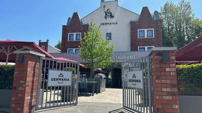 Eingang zum Restaurant Germania mit Sicht auf die Terrasse und Bäume