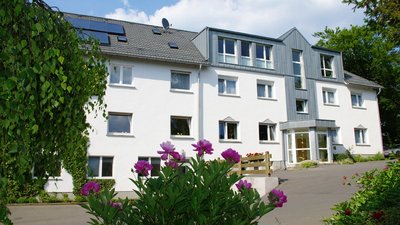 Helles Wohngebäude mit angrenzenden Blumen und Grünflächen