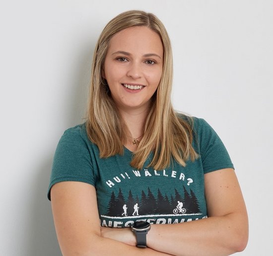 Individual with long hair wearing a t-shirt, posing confidently.