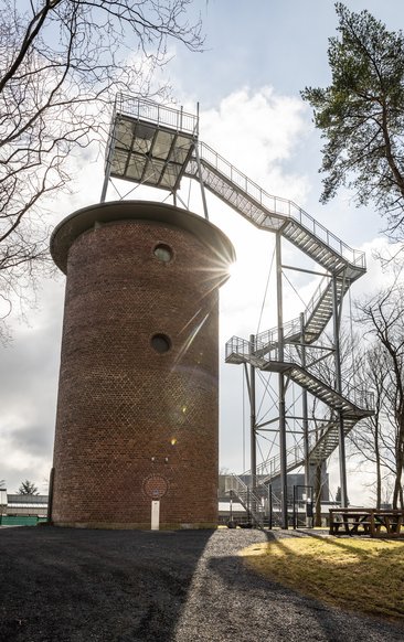Ansicht eines Wasserturms mit moderner Treppenstruktur und Sonnenschein