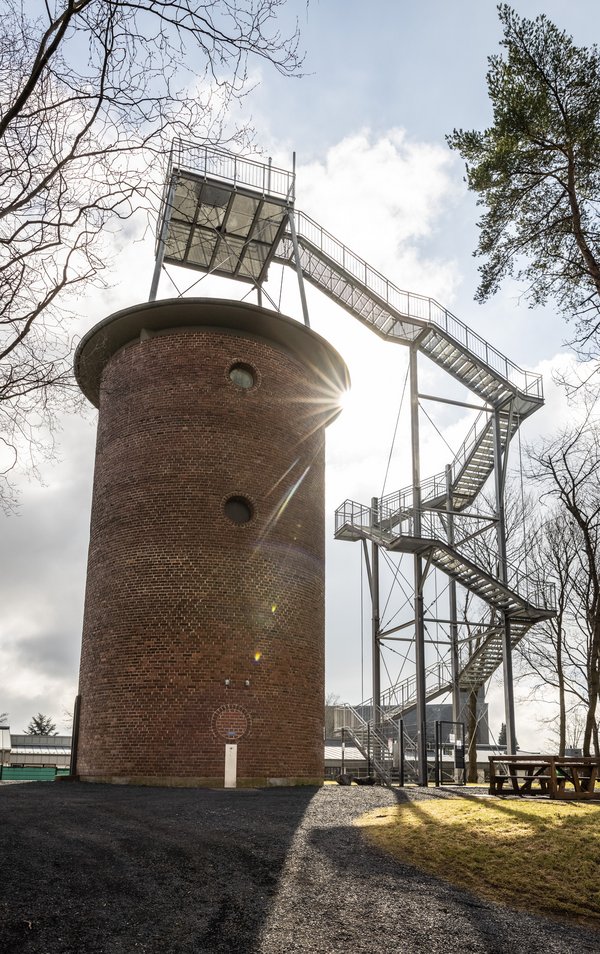 Ansicht eines Wasserturms mit moderner Treppenstruktur und Sonnenschein