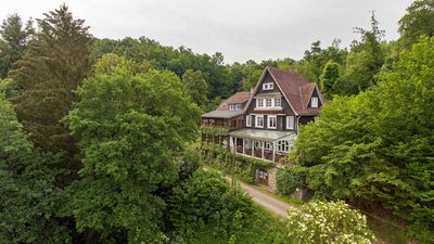 Ein schönes Haus, umgeben von Bäumen und grüner Landschaft