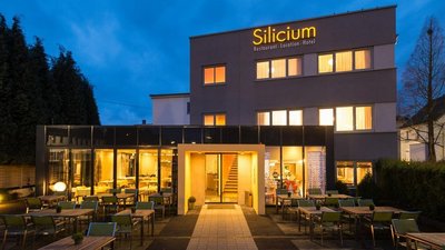 Illuminated facade of the Silicium restaurant and hotel during dusk