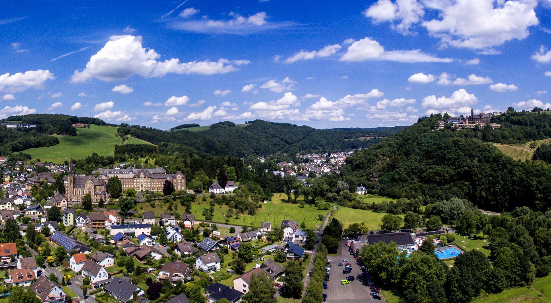 Luftaufnahme eines Dorfes mit Bergen und Wolken