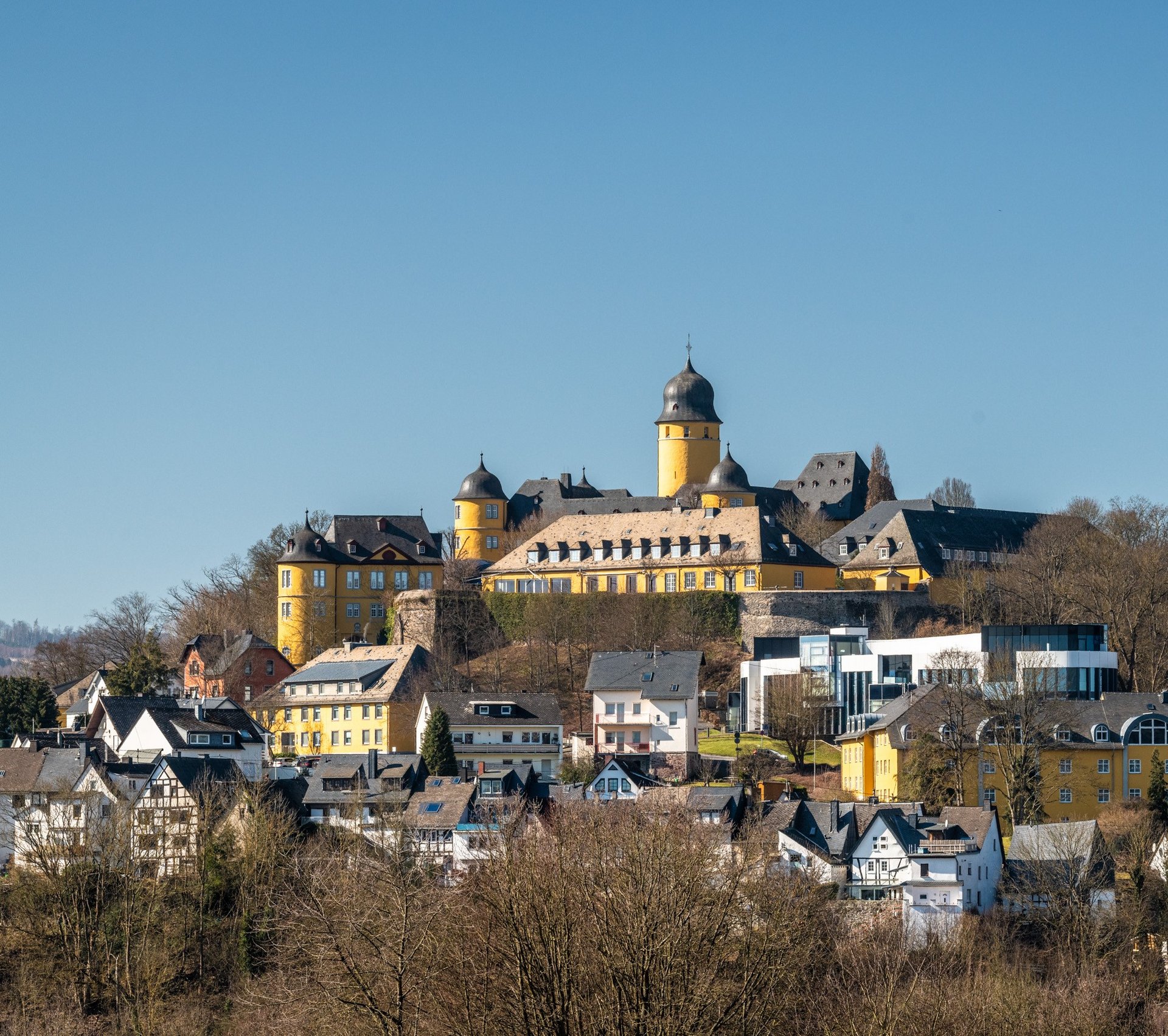 Historisches Schloss über einer Stadt mit bunten Häusern
