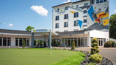 Exterior view of Glockenspitze Hotel featuring a unique climbing wall mural
