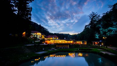 Schönes Gasthaus reflektiert im ruhigen Wasser bei Nacht