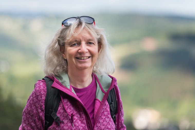 Portrait einer Wanderführerin im Freien mit braunem Hintergrund