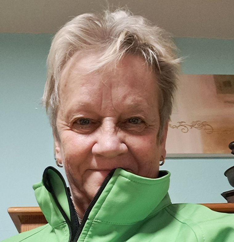 Silvia Patt mit grüner Jacke, die ihren Namen und Titel zeigt.