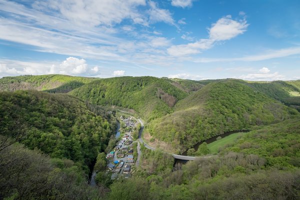 Panorama von Hügeln und einem kleinen Dorf im Tal unter blauem Himmel