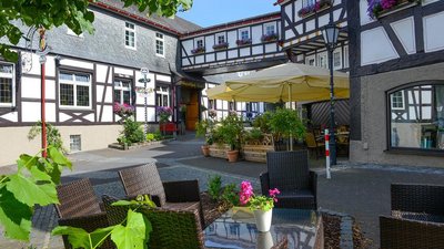 Sitzbereich mit Tischen und Pflanzen in einem malerischen Innenhof