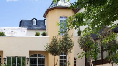 Fassade eines stilvollen Gebäudes umgeben von Grünpflanzen