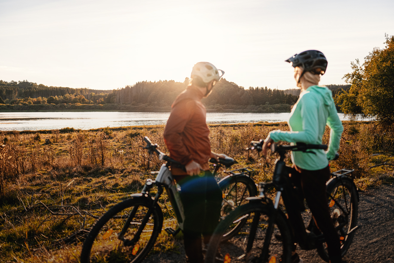 Zwei Radfahrer genießen den Blick auf das Wasser bei Sonnenuntergang