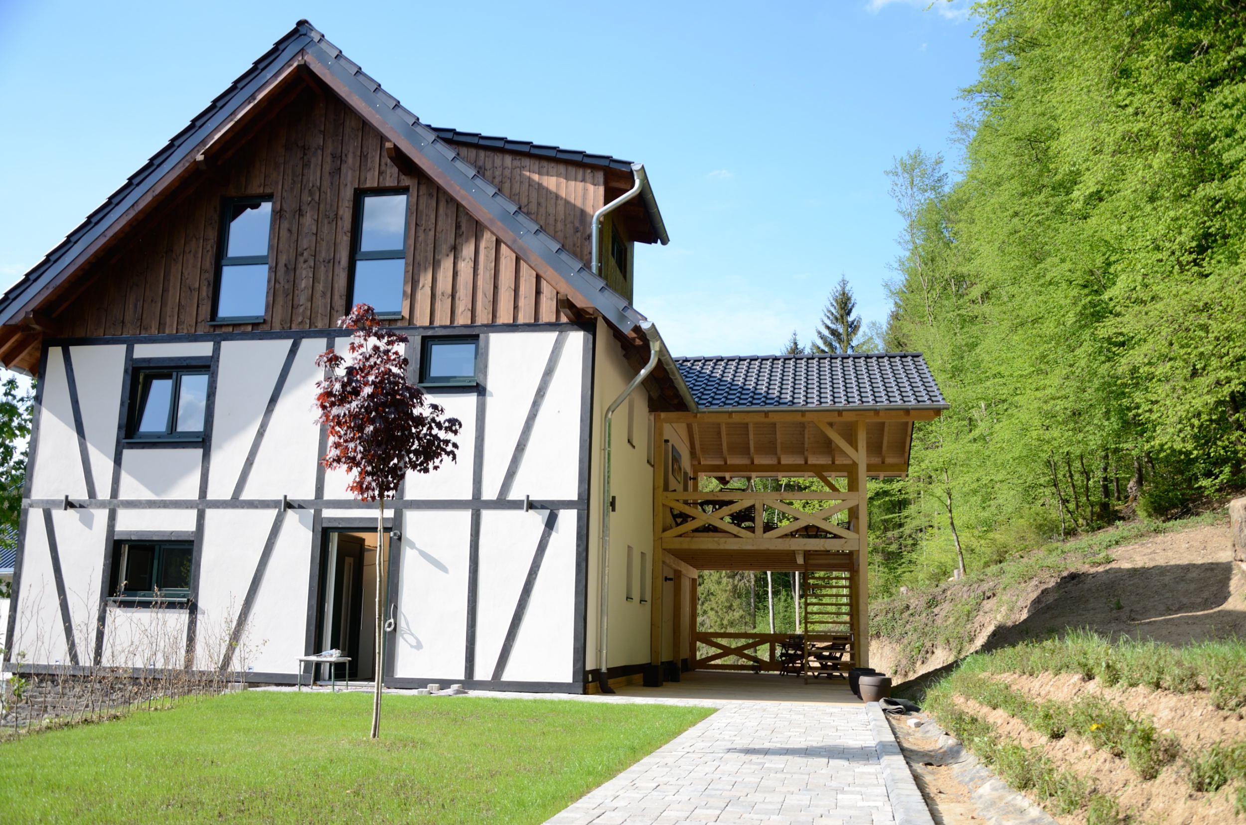 Fachwerkhaus in der Natur mit neuem Anbau und Parkplatz