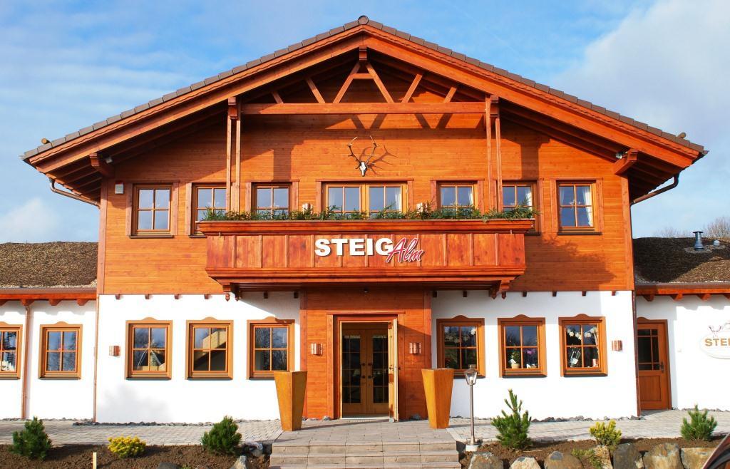 Holzgebäude mit Fenstern, Balkon und auffälliger Beschilderung